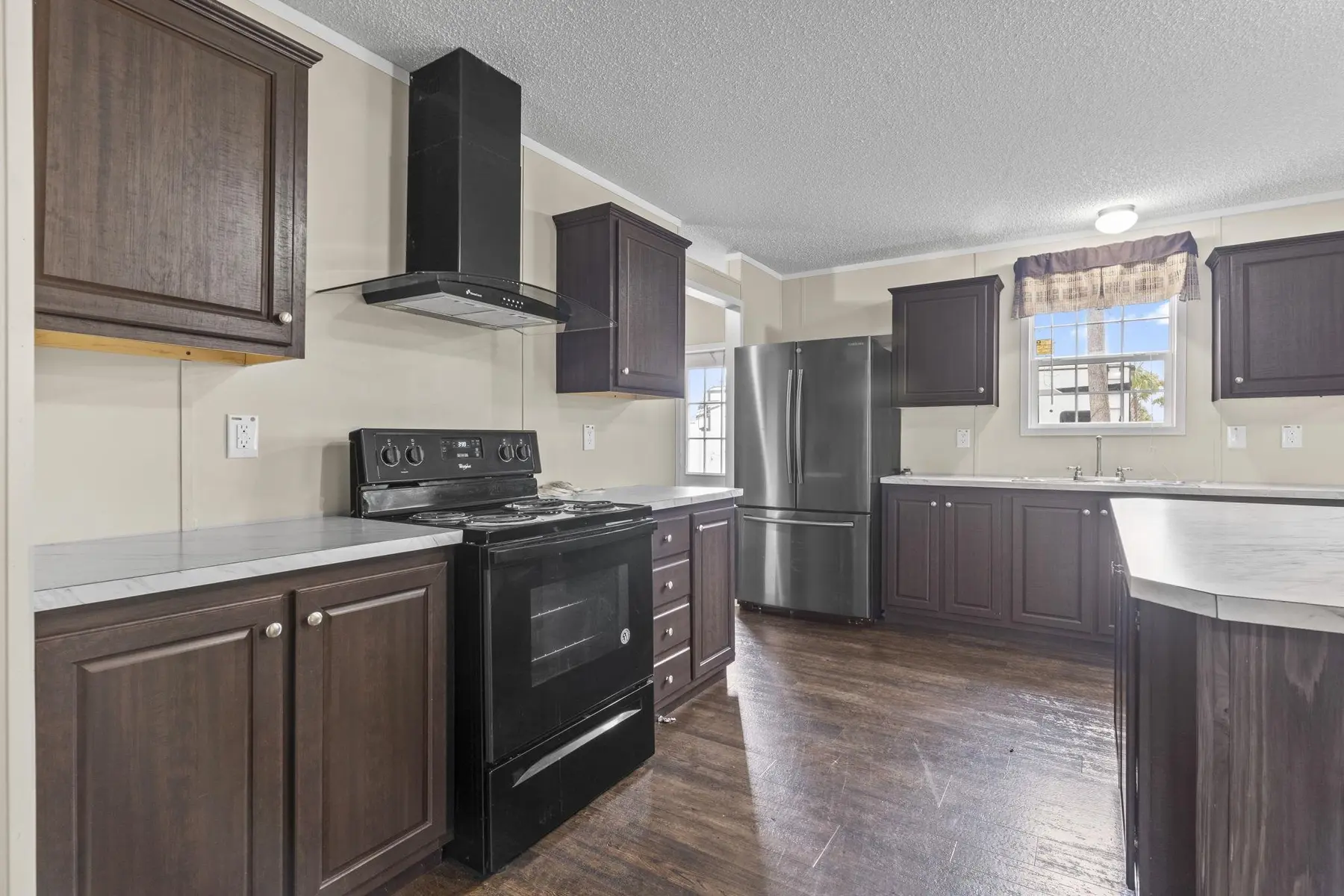 Kitchen range, microwave, range hood and dark cabinetry