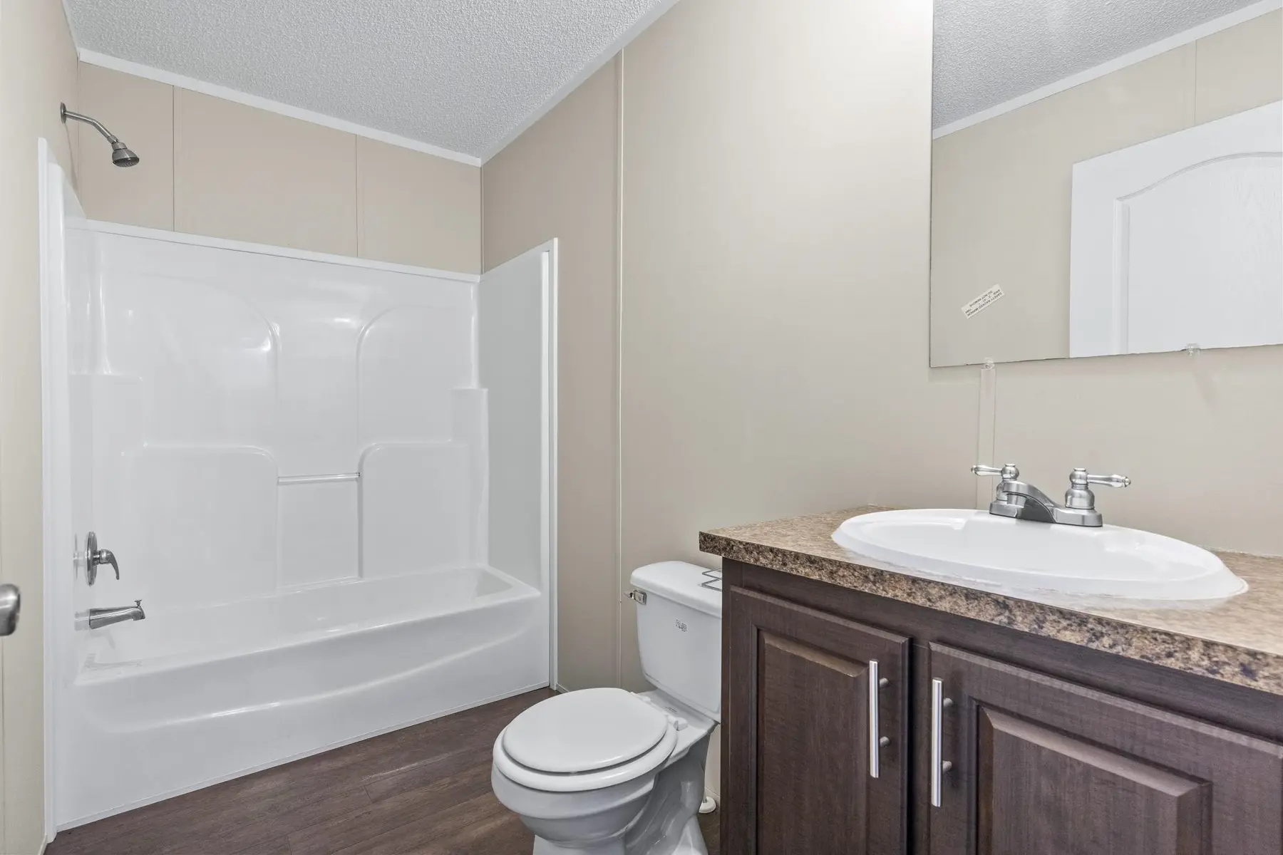 Full bathroom with tub-shower combination, toilet and vanity
