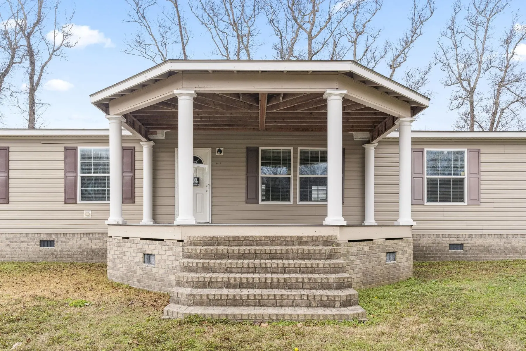 Front exterior with covered porch, steps and multiple windows