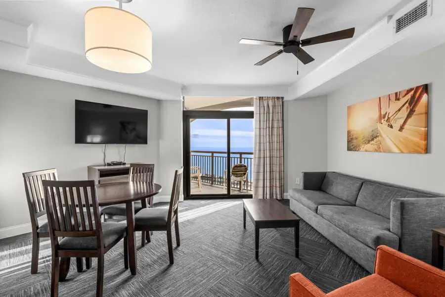 Furnished living and dining area with balcony access