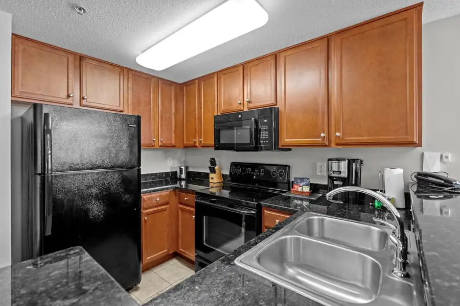 Kitchen with breakfast bar and black appliances