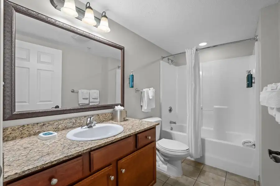 Full bathroom with granite vanity and tub-shower combination
