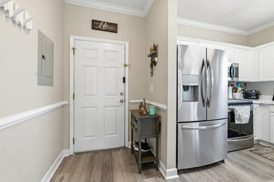 Entry foyer beside the white kitchen cabinetry