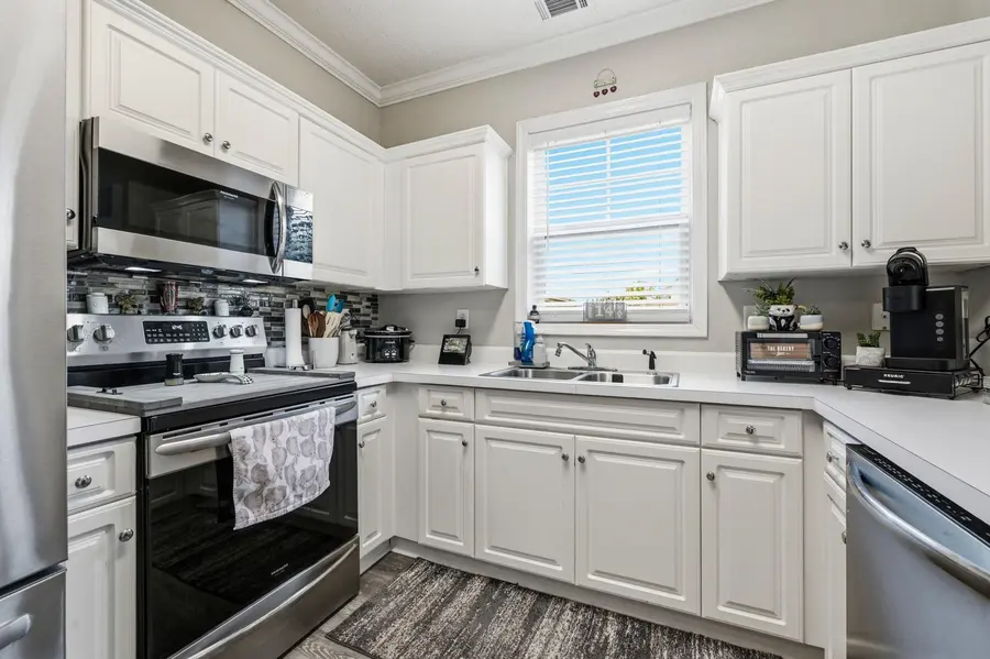 Kitchen with white cabinetry, quartz counters and stainless-steel appliances