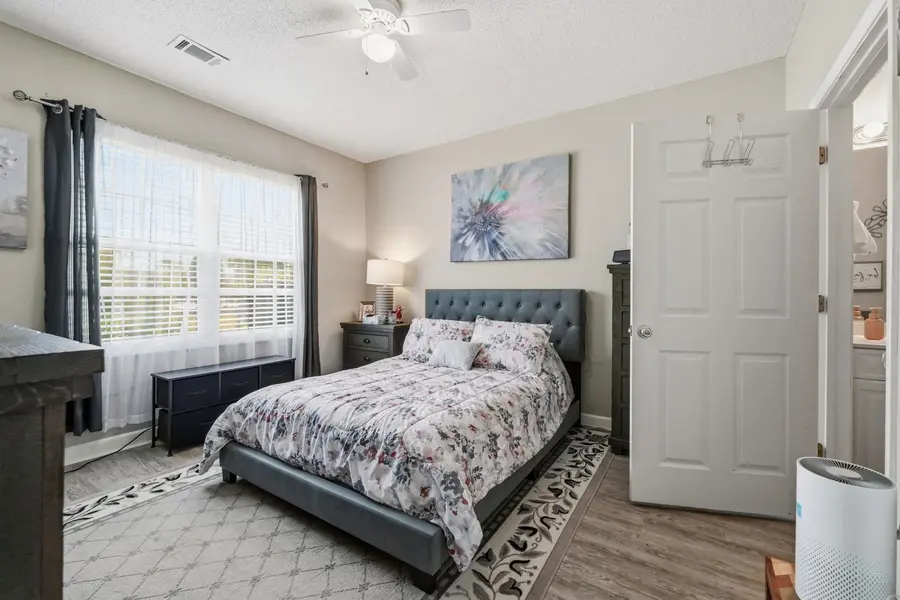 Primary bedroom with windows and ceiling fan