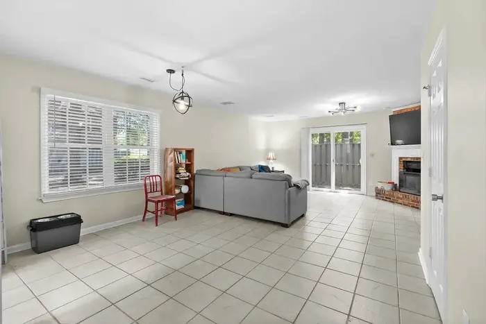 Main living area with tiled floor, windows and brick fireplace wall