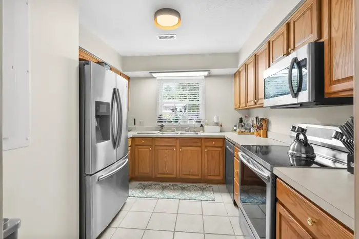 Galley kitchen with wood cabinetry and stainless-steel appliances