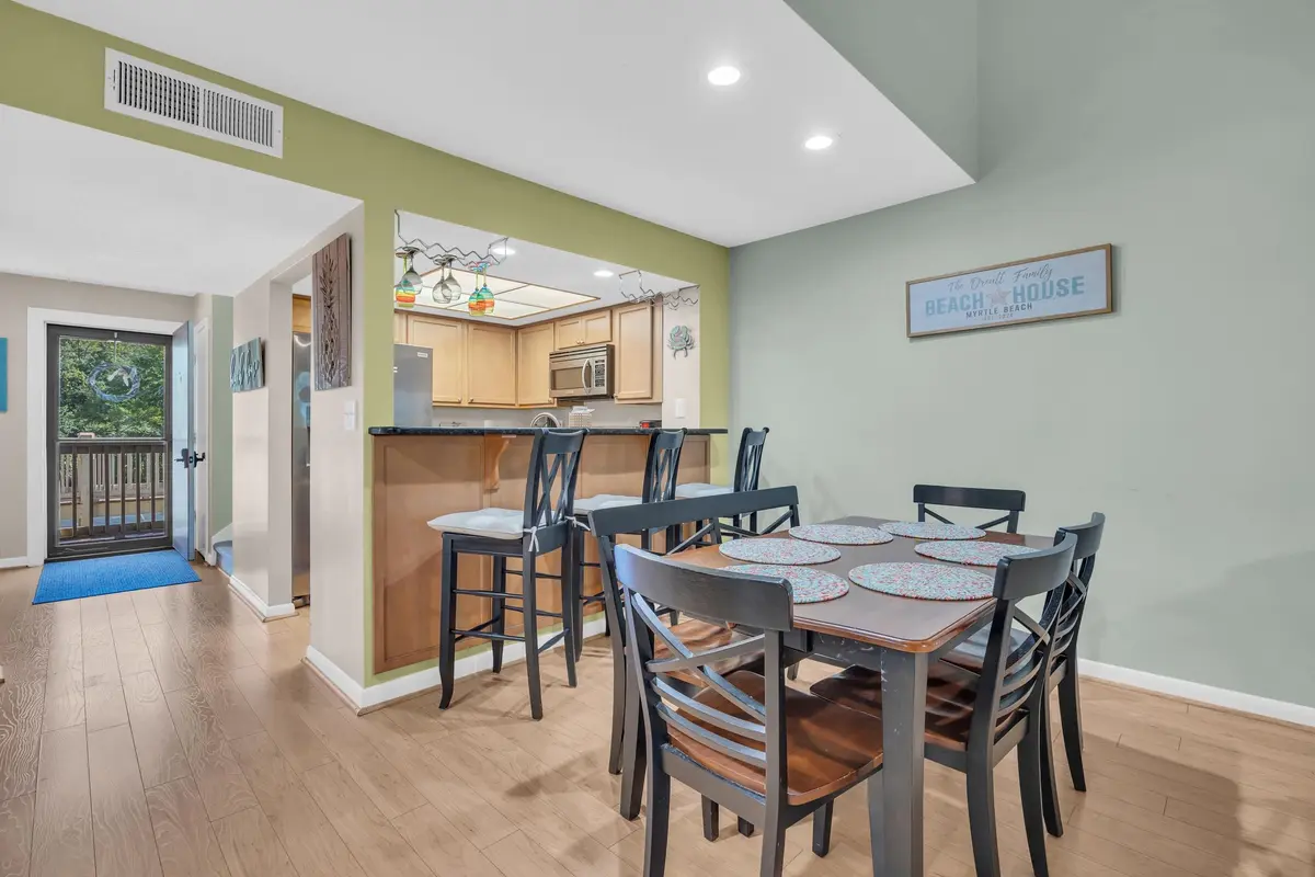 Dining table beneath a recessed ceiling light