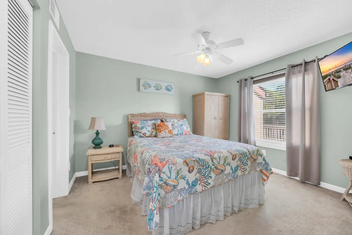 Primary bedroom with ceiling fan, windows, and porch access