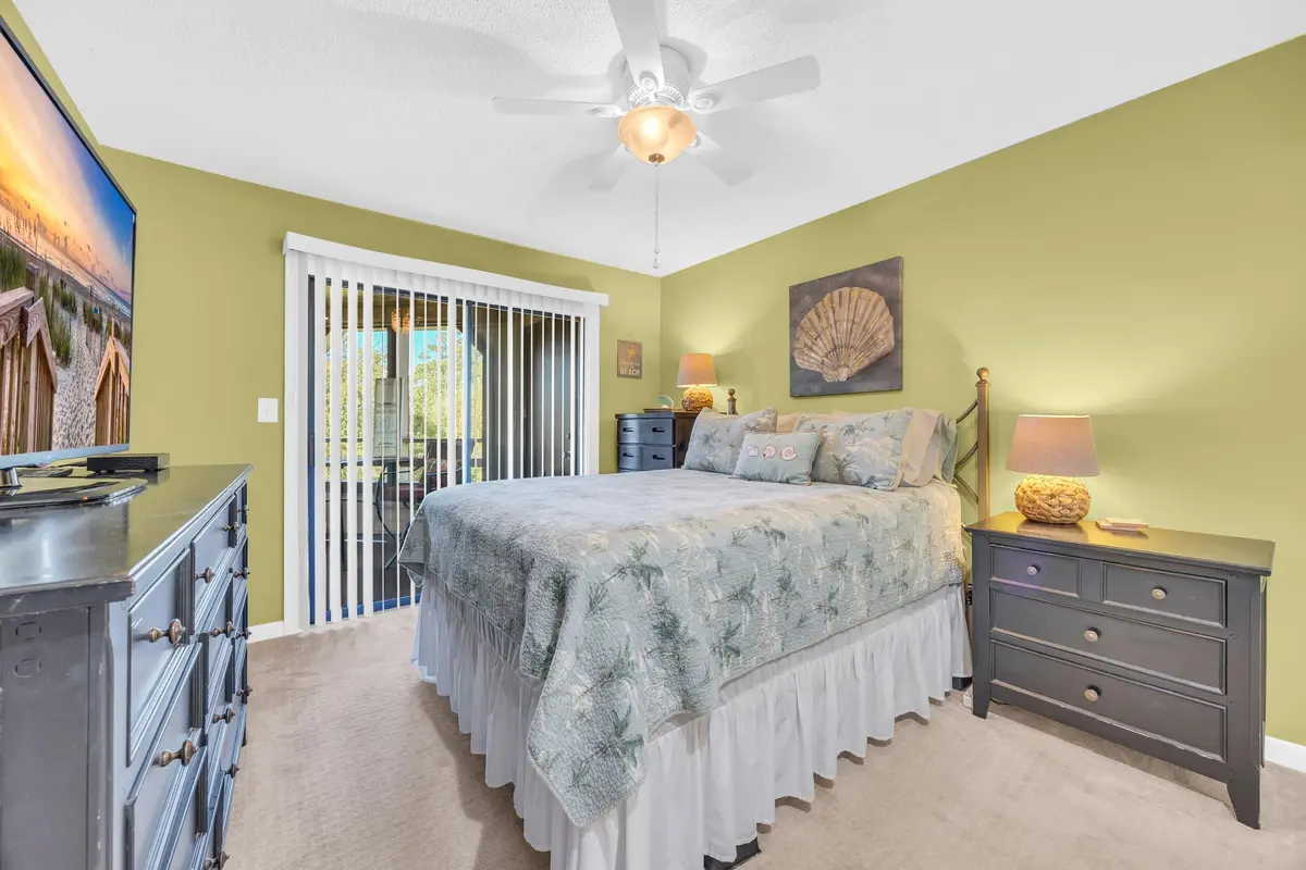 Main-level bedroom with ceiling fan and sliding glass doors