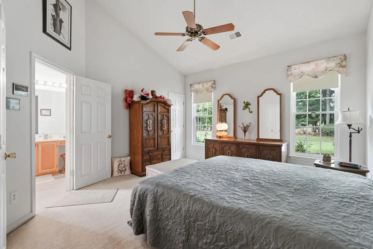Primary bedroom with ceiling fan and rear-facing windows
