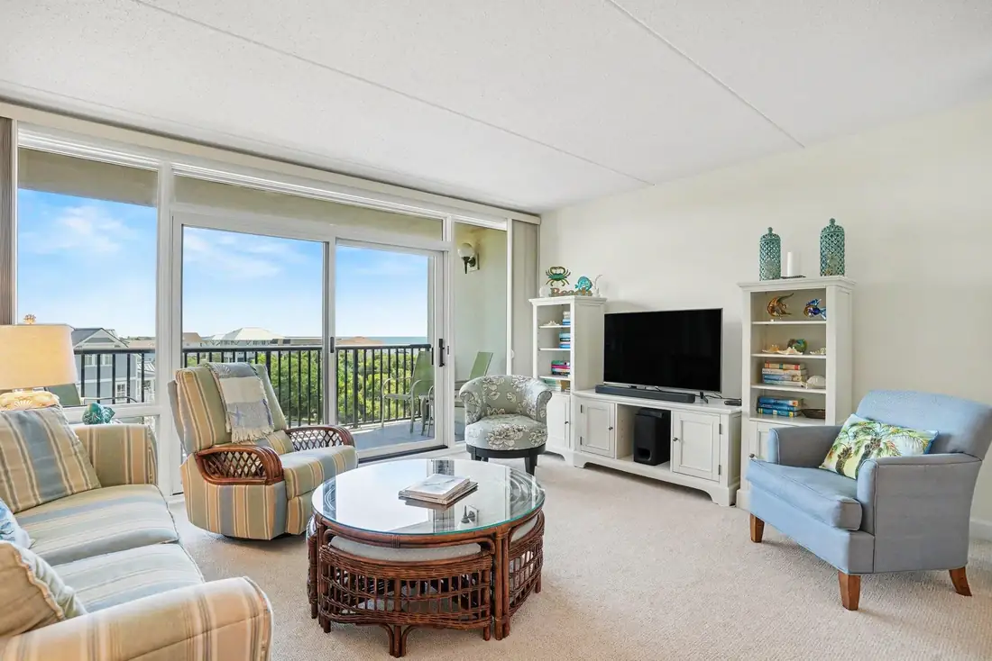 Furnished living room with seating and balcony windows