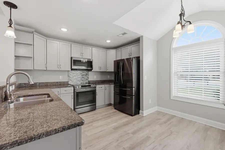 Kitchen with white cabinetry, granite counters and stainless-steel appliances