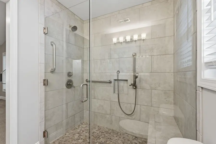 Tiled walk-in shower with glass enclosure