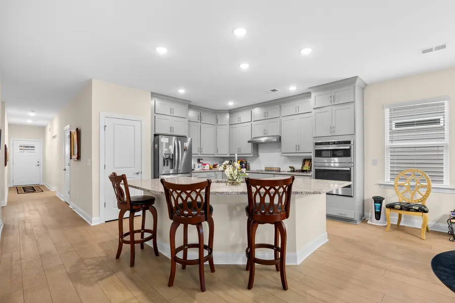 Kitchen with gray cabinetry, granite counters and work island